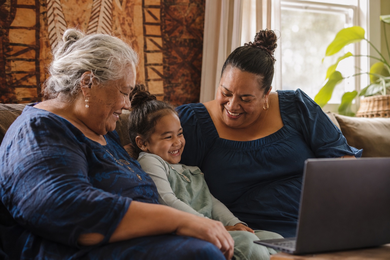 Three generations of a Pasifika family laughing together after a video health call